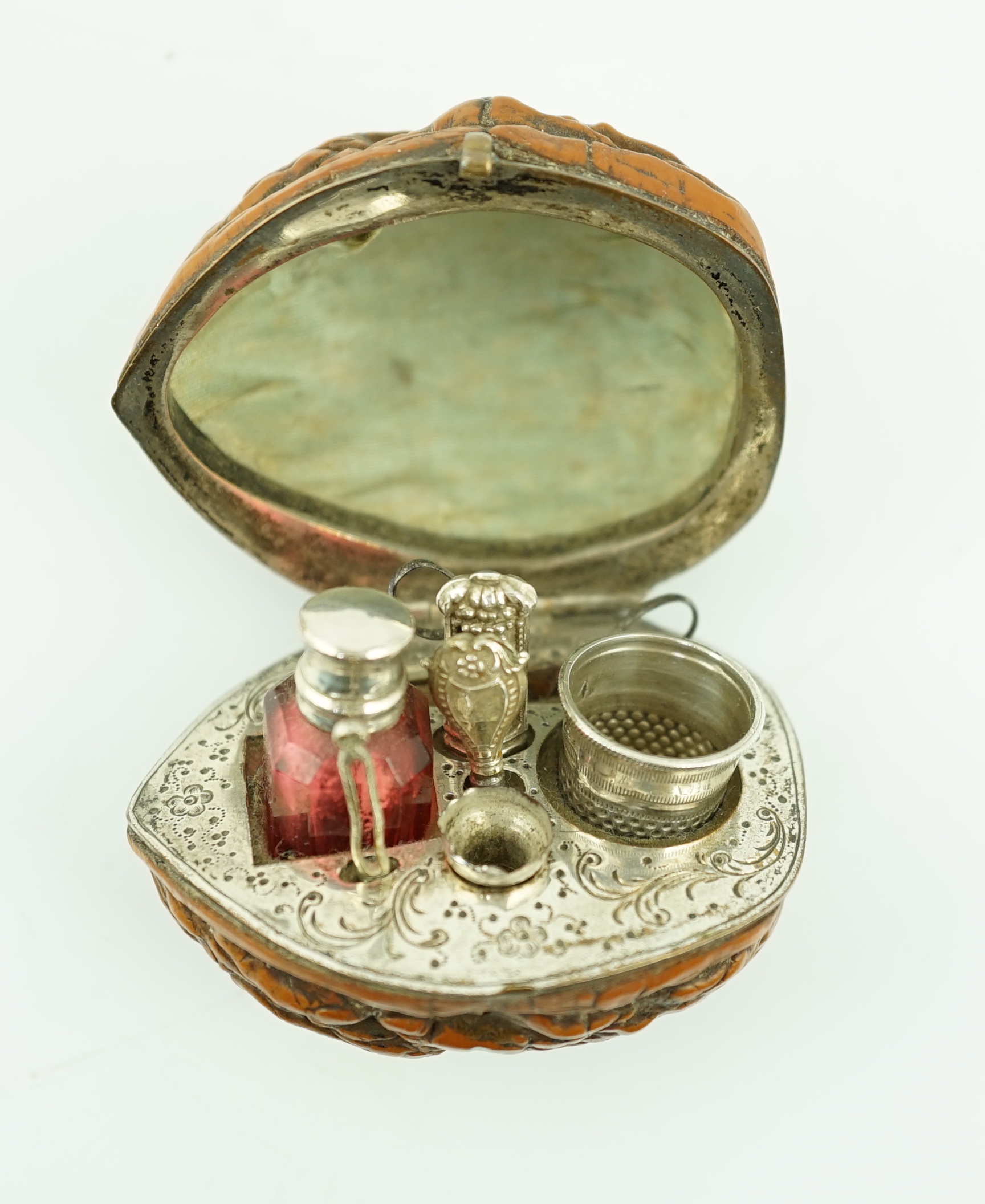 A 19th century French novelty etui case, modelled as a walnut, containing six silver or silver mounted implements